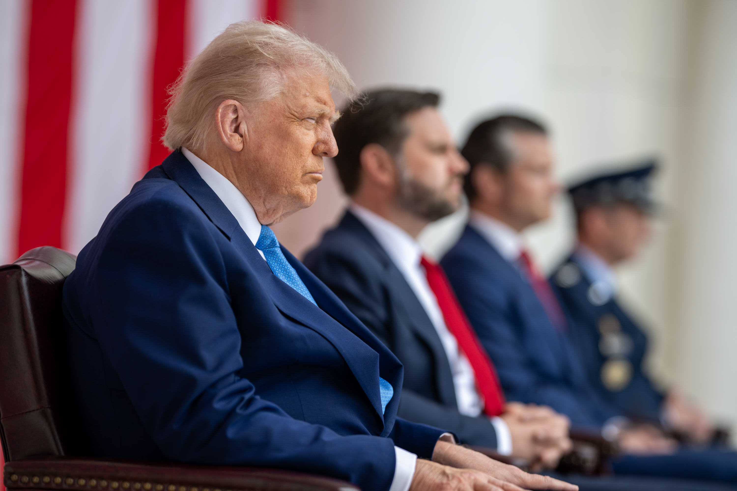 Donald Trump seated with officials at Arlington National Cemetery on Memorial Day in May 2025