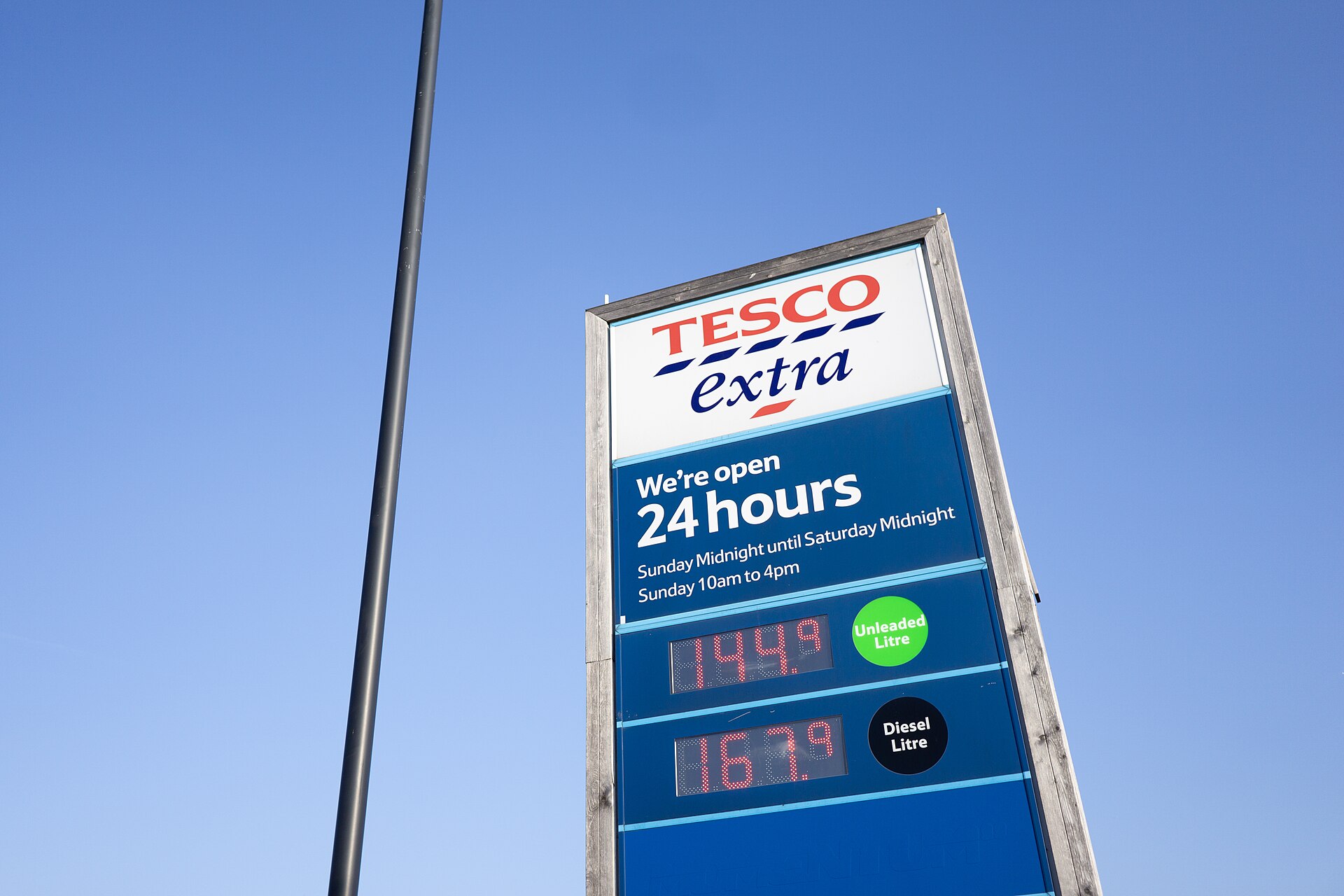 A Tesco Extra forecourt sign displaying unleaded and diesel prices per litre