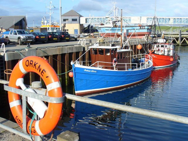 Blue and red fishing boats moored in Stromness harbour in Orkney