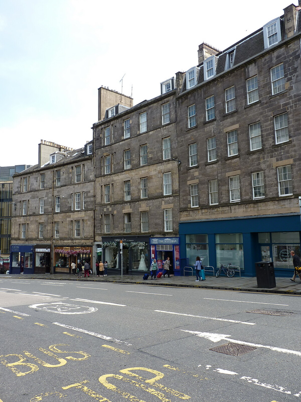 Stone tenement flats above shops on Leith Street in Edinburgh