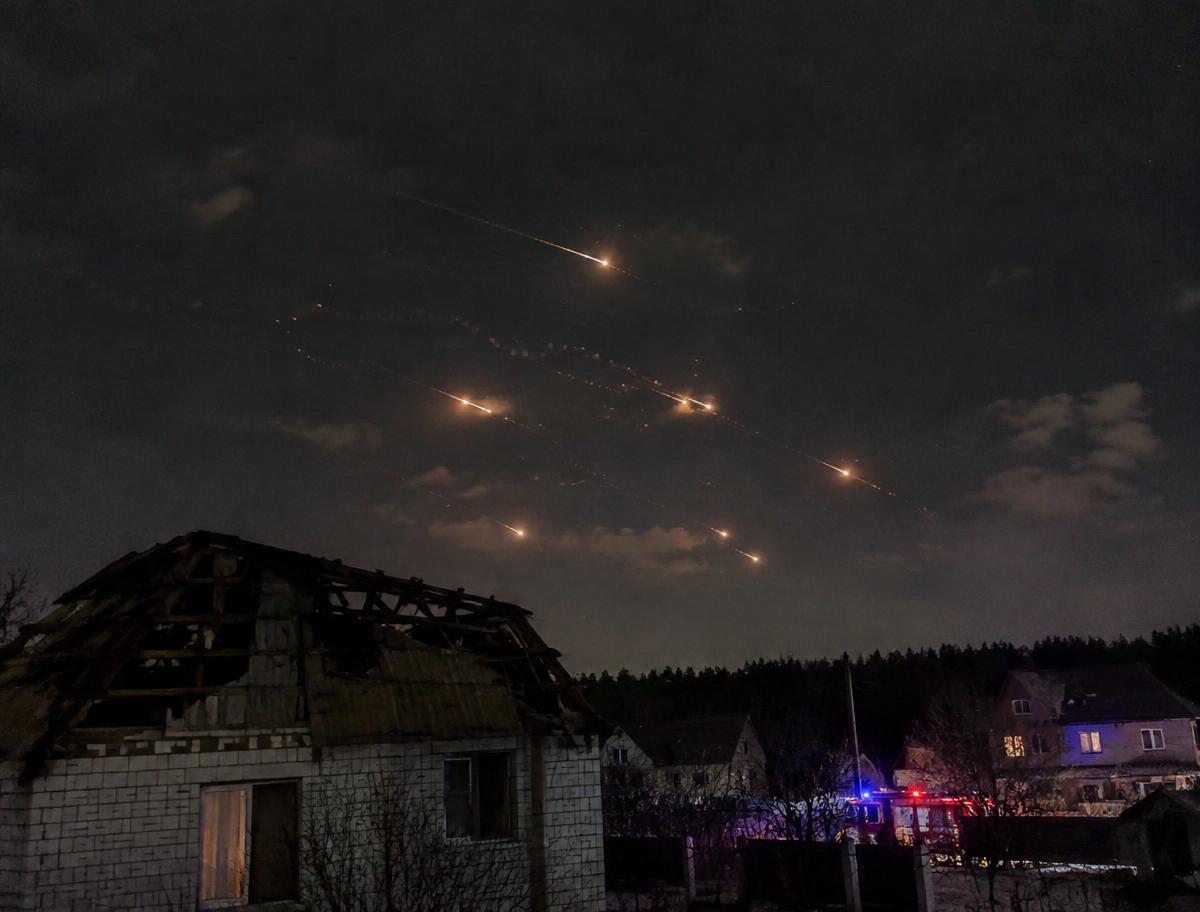 Air defence streaks in the night sky above a damaged house roof on the outskirts of Moscow