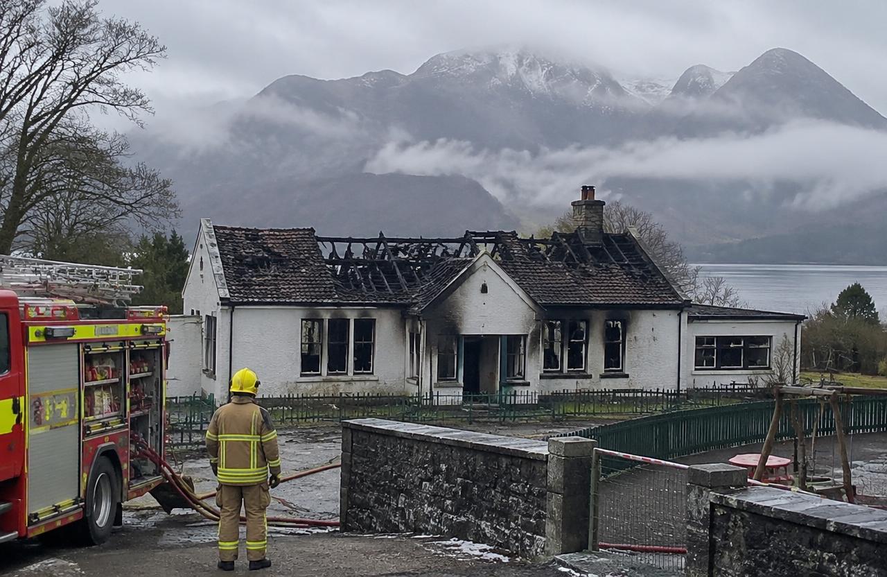 Fire-damaged Highland primary school with a firefighter and fire engine outside