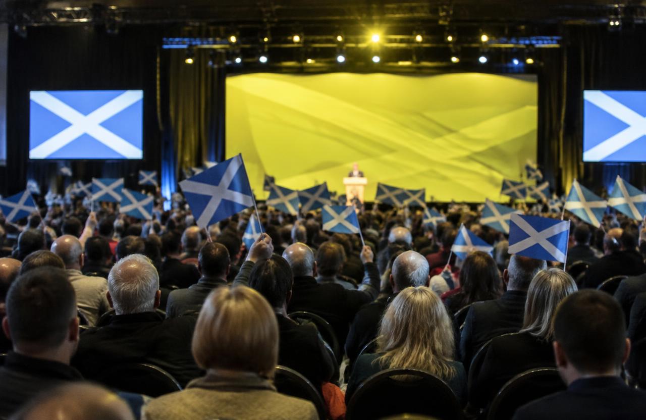 SNP conference delegates waving Saltire flags as a speaker addresses the hall